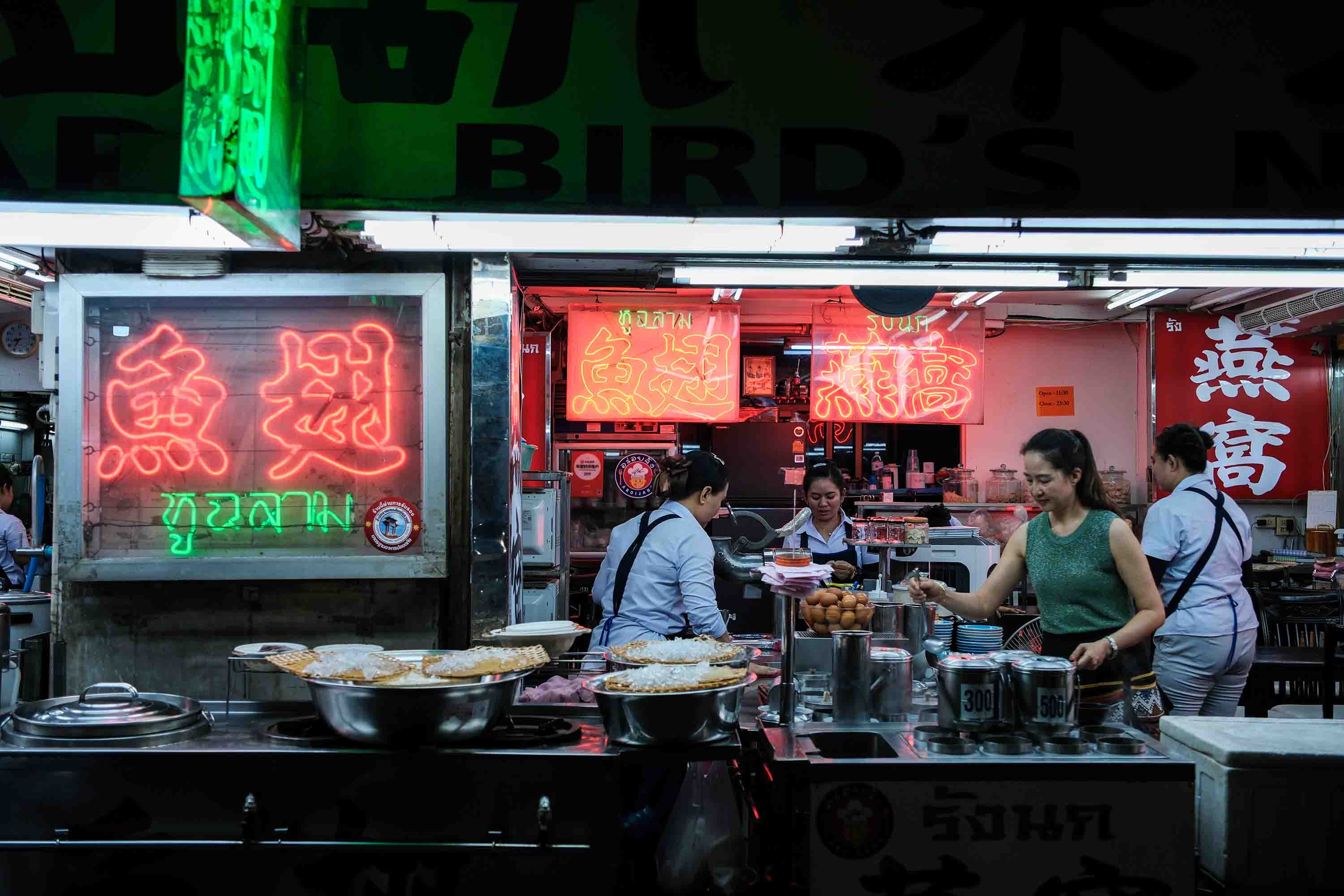 Ngawang Rai street photography of a bangkok restaurant, where the people are cooking.